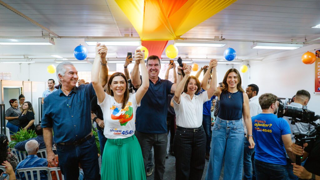Lideranças políticas com mãos erguidas em sinal de união.