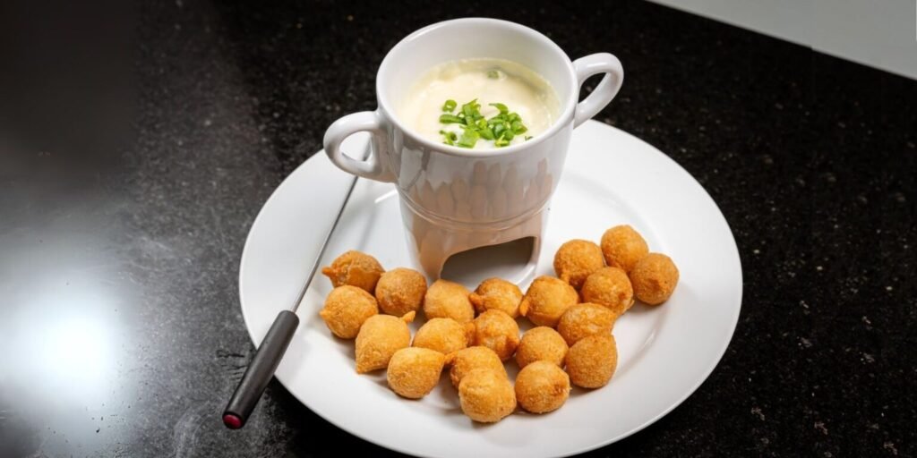 Fondue de queijo cremoso servido com petiscos fritos crocantes.