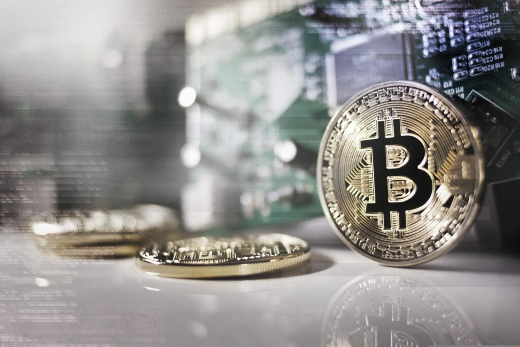 Moeda de Bitcoin física sobre fundo de placa de circuito.