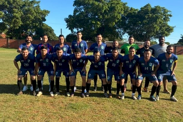 Time de futebol amador posando para foto no campo.