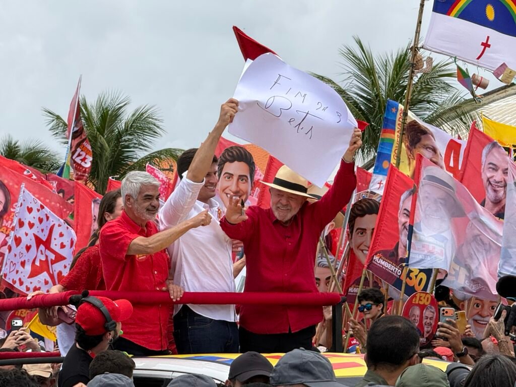 Lula em comício político segurando cartaz escrito 'Fim das Bets'.