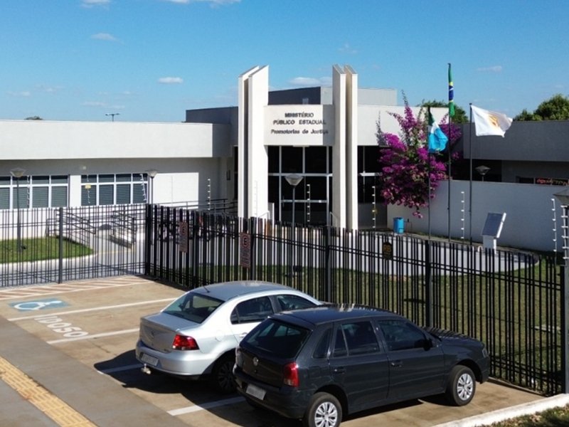 Fachada do prédio do Ministério Público Estadual com estacionamento frontal.