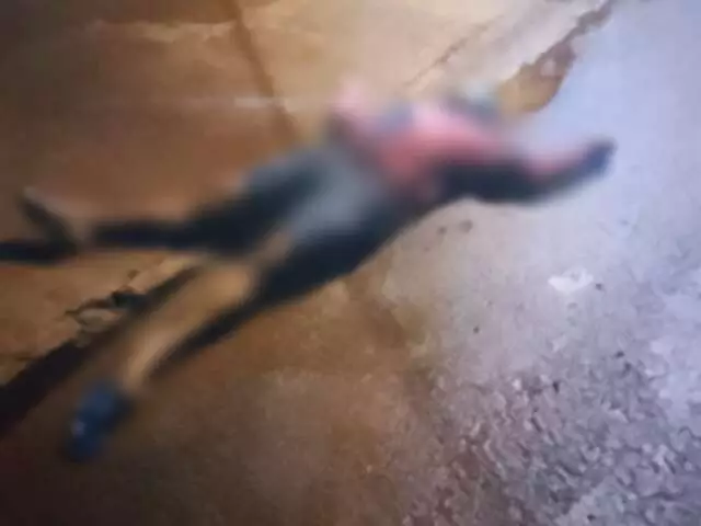 Figura desfocada de herói caída no chão de uma rua.