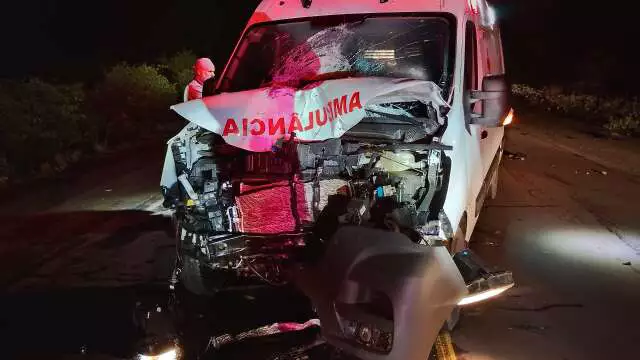 Ambulância branca com a frente totalmente destruída após colisão severa.