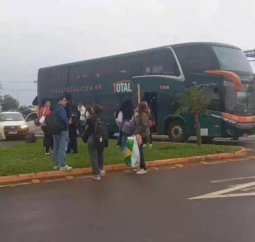Ônibus verde de dois andares com passageiros embarcando.