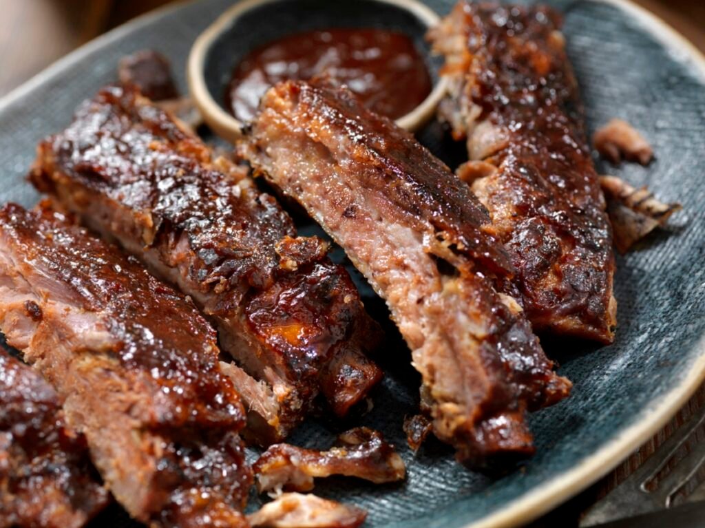 Costelinhas de porco ao molho barbecue suculentas no prato.
