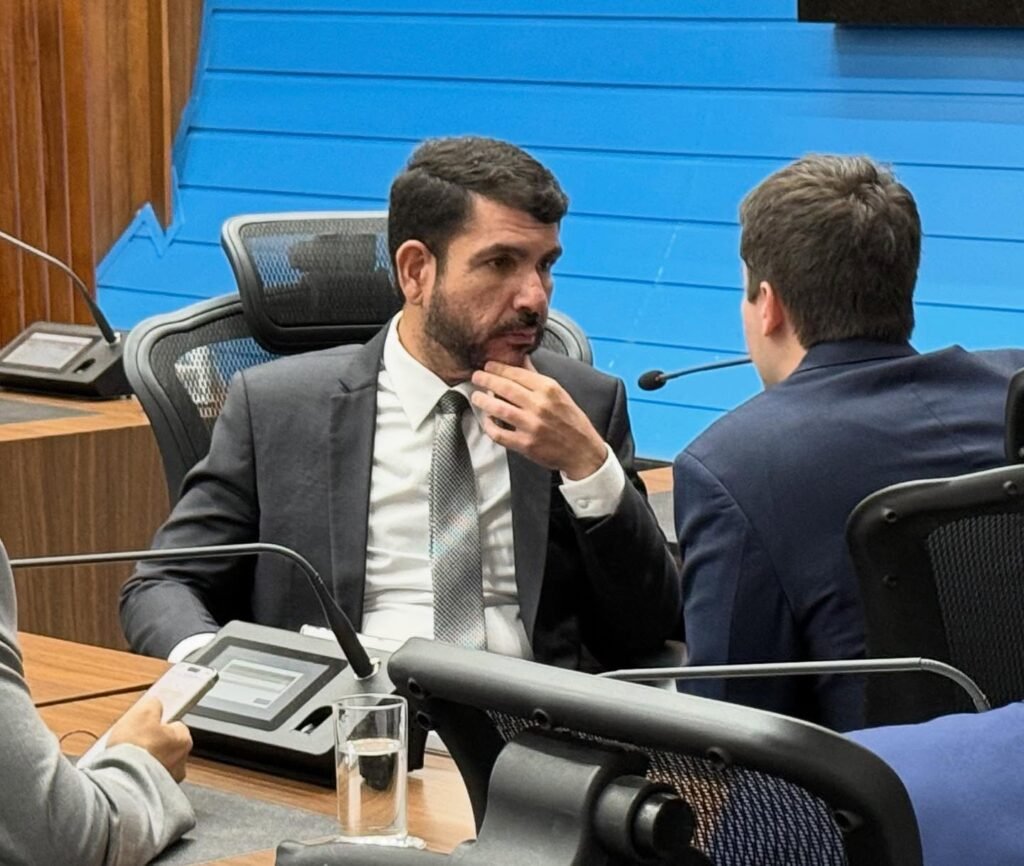 Homem de terno em debate durante sessão legislativa.