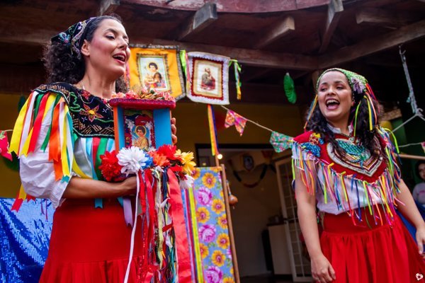 Duas mulheres em trajes típicos coloridos celebrando cultura popular brasileira.