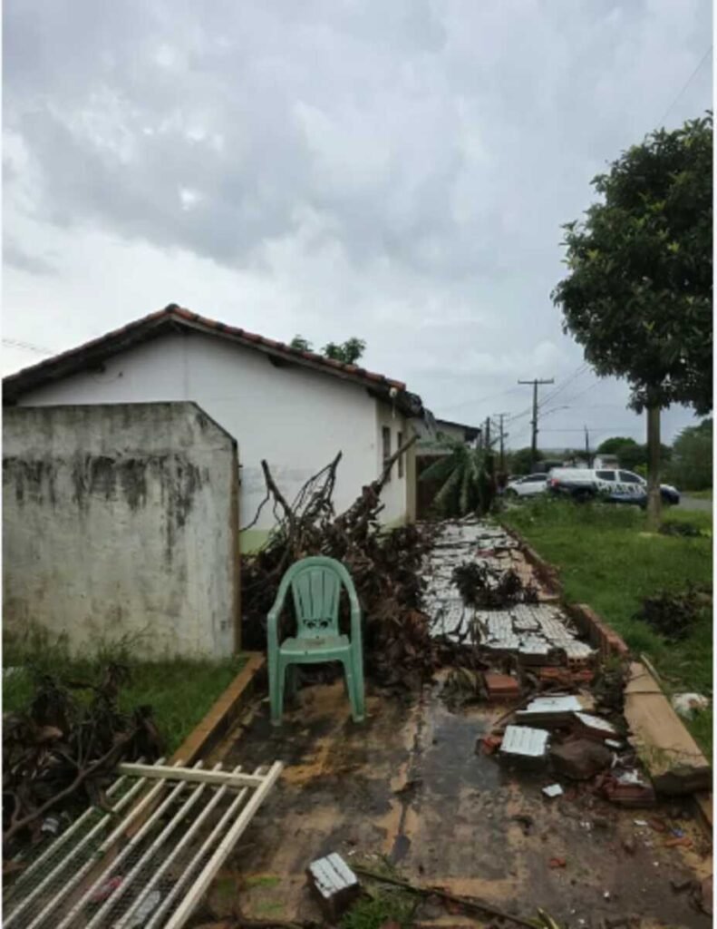 Casa com danos estruturais e destroços após um temporal.