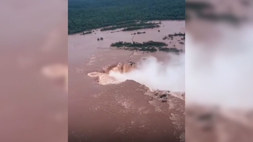 Vista aérea das Cataratas do Iguaçu com águas barrentas e agitadas.