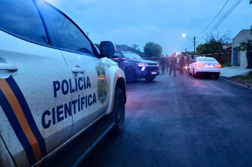 Viatura da Polícia Científica em rua isolada para investigação.