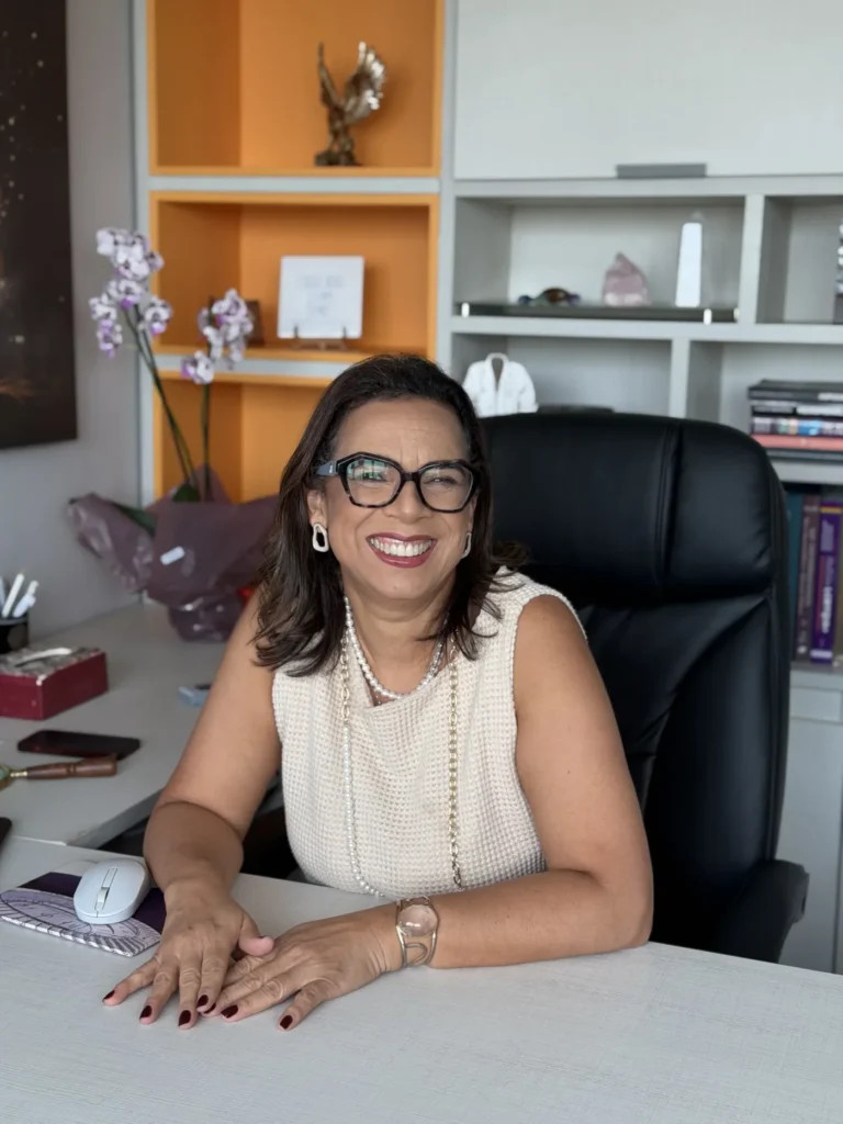 Mulher sorridente de óculos sentada em um escritório moderno.