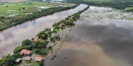 Vista aérea de casas cercadas por águas de inundação.