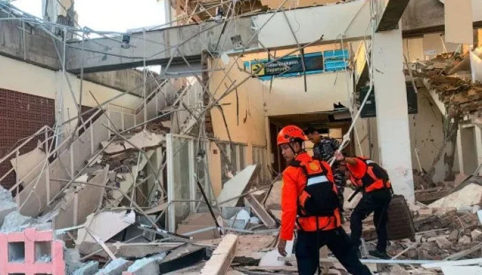 Equipes de resgate inspecionando escombros em terminal de aeroporto danificado.