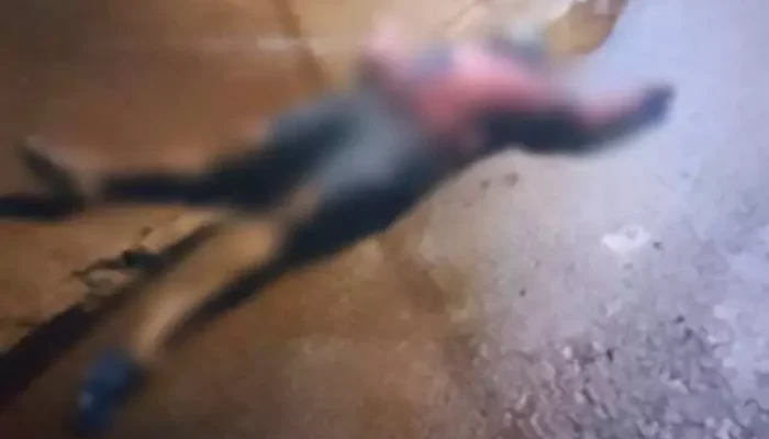 Figura desfocada de herói caída no chão de uma rua.