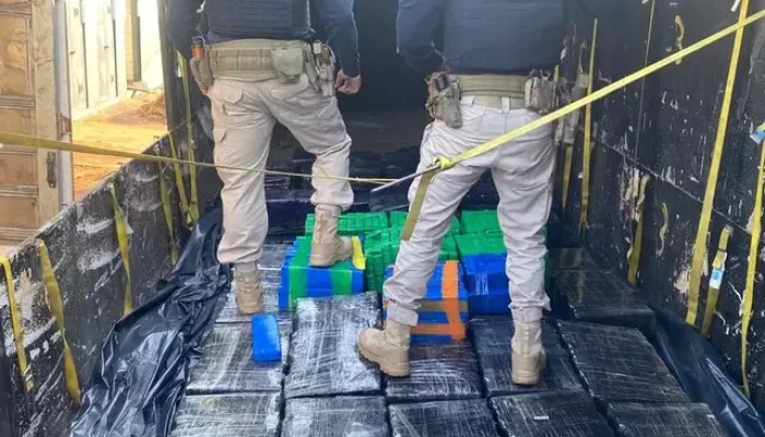 Policiais sob carga de maconha encontrada em carreta (Foto: Divulgação)