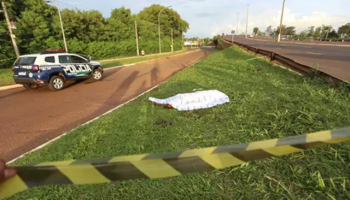 O corpo da vítima coberto no canteiro da Avenida Duque de Caxias (Foto: Paulo Francis)