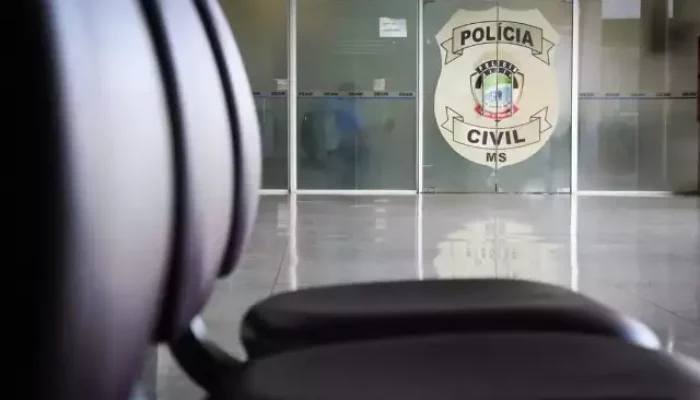 Logotipo da Polícia Civil de MS em porta de vidro.