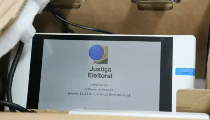 Tela de urna eletrônica brasileira inicializando dentro de uma caixa.