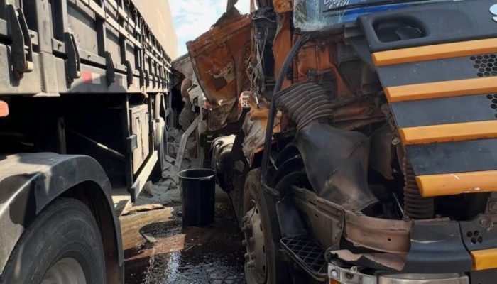 Caminhão com cabine destruída após colisão lateral com carreta.