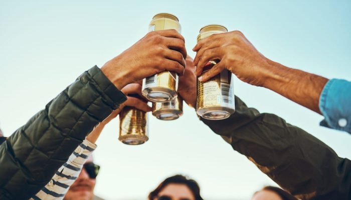 Foto: 1 de 1 Na foto, várias pessoas brindando com latas - Metrópoles - Foto: Re