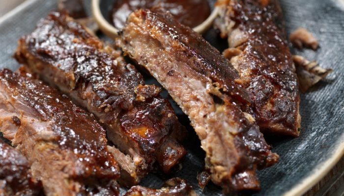 Costelinhas de porco ao molho barbecue suculentas no prato.