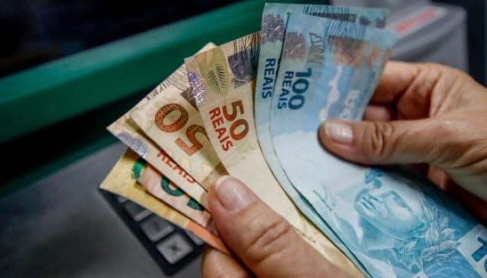 Pessoa segura cédulas de real — Foto: Pessoa segura cédulas de real | Divulgação