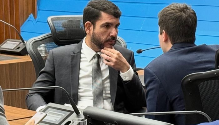 Homem de terno em debate durante sessão legislativa.