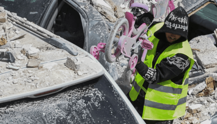 Homem carrega bicicleta infantil em área de Israel atacada pelo Irã — Foto: Home
