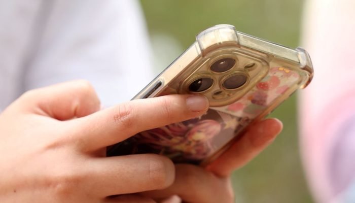 Menina usa telefone em Sydney — Foto: Menina usa telefone em Sydney | 22/11/2025