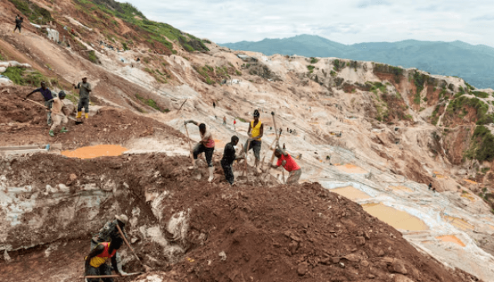 Trabalhadores escavam na mina de coltan de Rubaya, na cidade de Rubaya, controla
