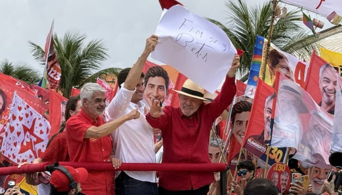 Lula em comício político segurando cartaz escrito 'Fim das Bets'.