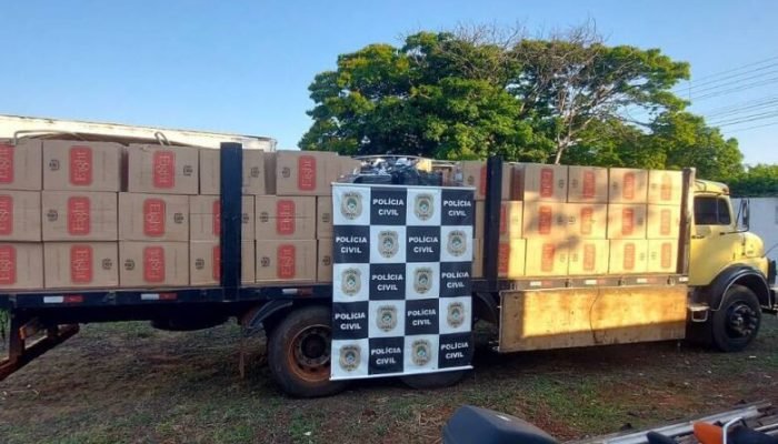 Caminhão amarelo carregado com caixas apreendidas pela Polícia Civil.