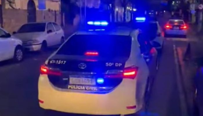 Carro da polícia em rua escura com as luzes ligadas — Foto: carro da policia em