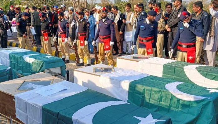 Foto: Policiais e moradores se reúnem ao lado dos caixões cobertos com a bandeir