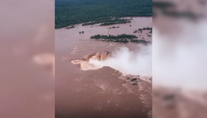 Vista aérea das Cataratas do Iguaçu com águas barrentas e agitadas.
