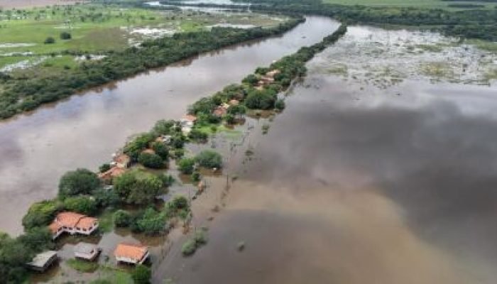 Vista aérea de casas cercadas por águas de inundação.